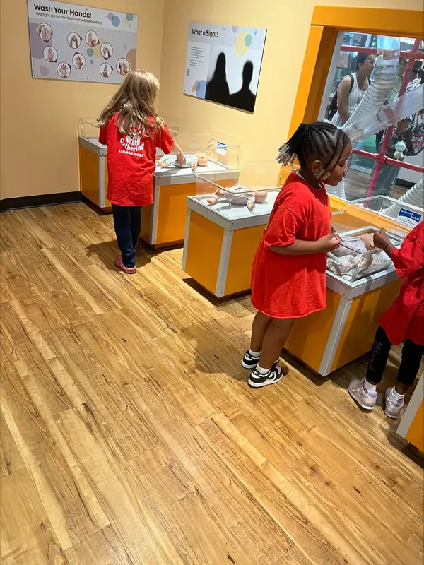 Summer campers in red shirts at a museum discovery exhibit