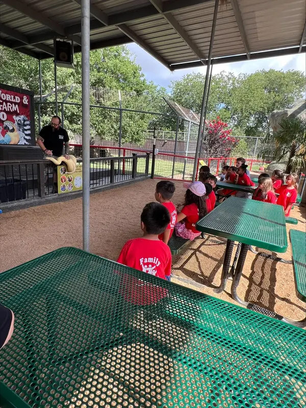 Summer campers at picnic tables under a pavilion