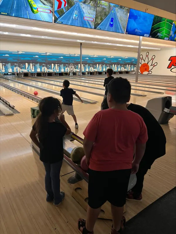 A summer camper bowling during a field trip