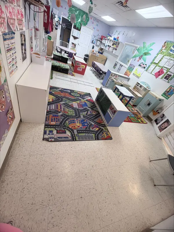 Toddler classroom with a road-map play rug and colorful wall displays